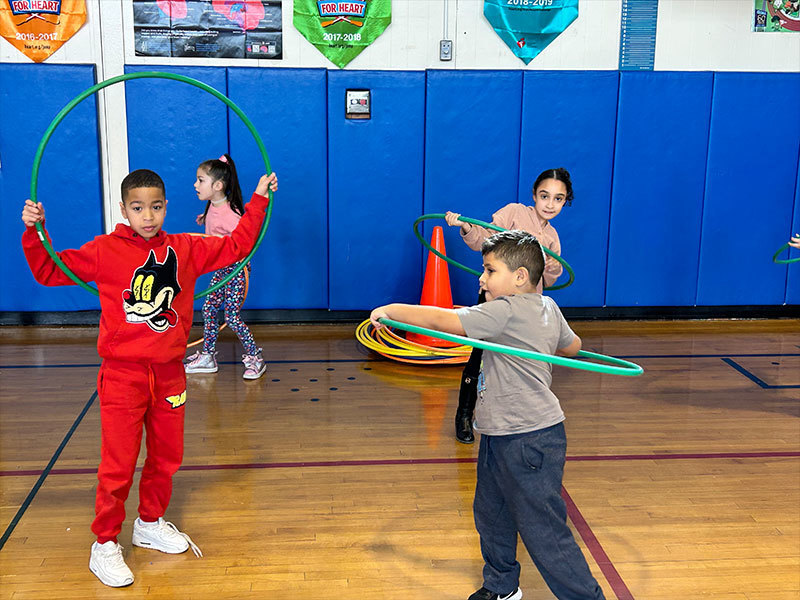 Students using hoola hoops while in the gym