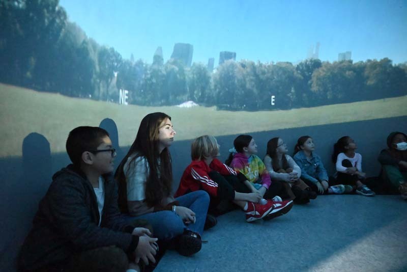 Students sitting a planetarium