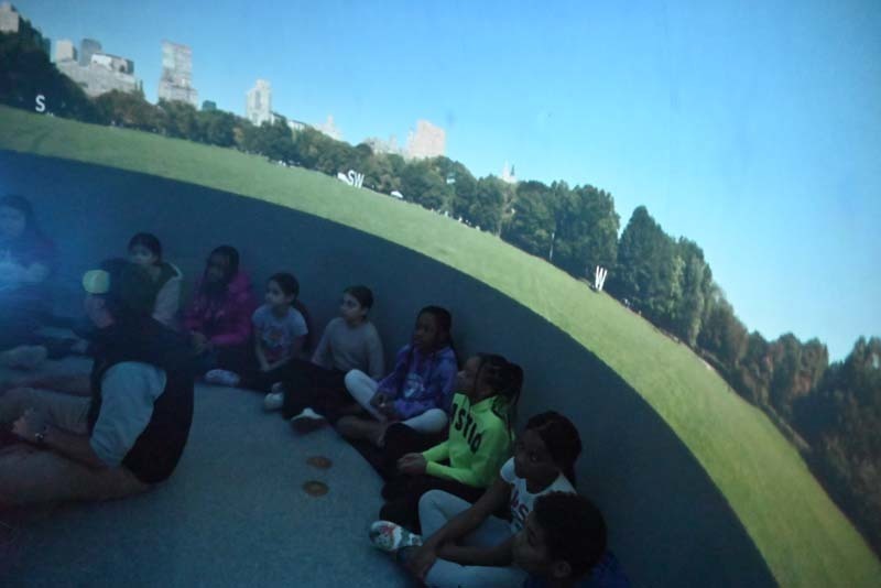 Students sitting a planetarium