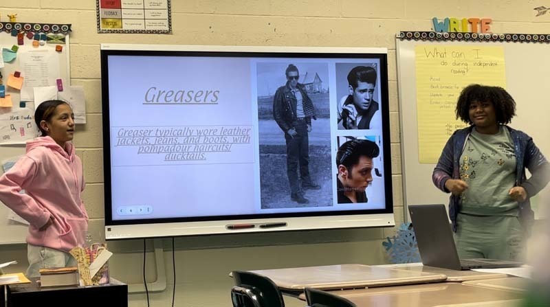 Two students presenting a Google Slideshow on Greasers