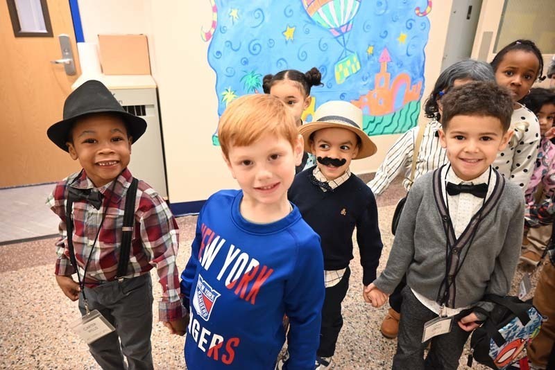 Students dressed up for the 100th day of school and smiling at the camera