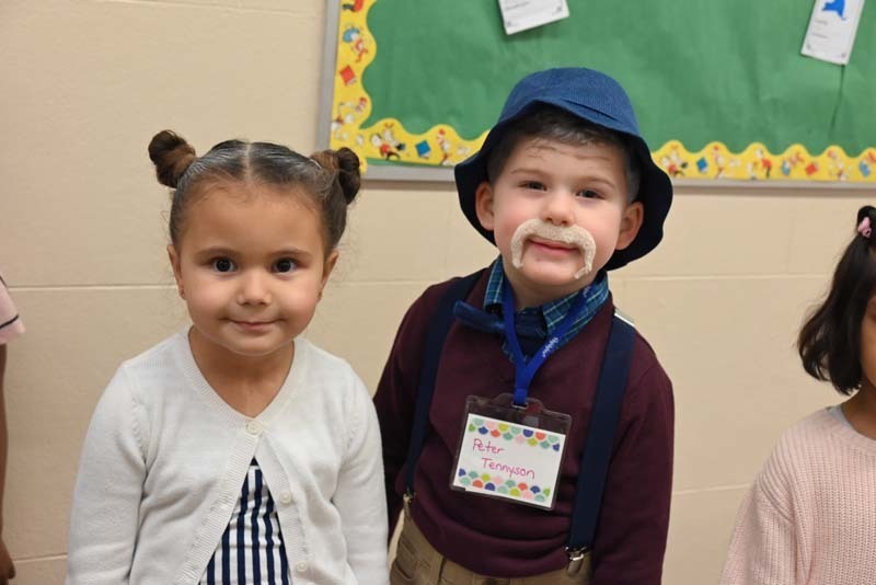 Students dressed up for the 100th day of school and smiling at the camera