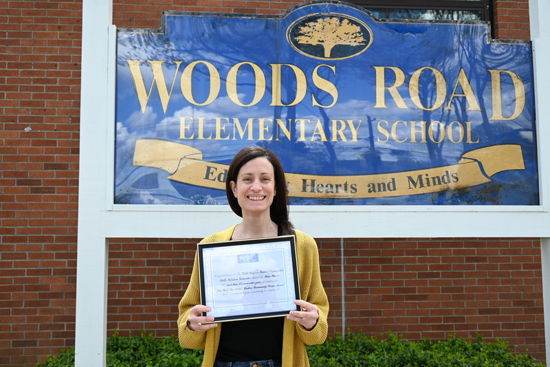 Woods Road Elementary School teacher Marie Rivera holding award